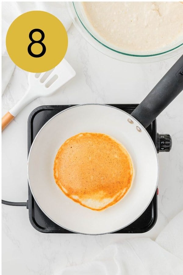 The pancake flipped and golden brown in the pan.