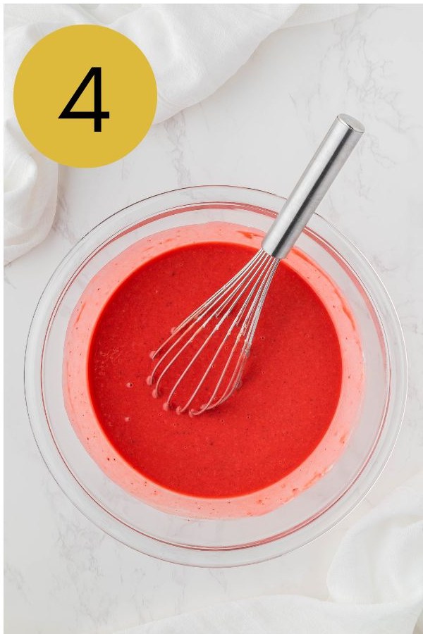 The pancake batter whisked smooth and turned red with food coloring.
