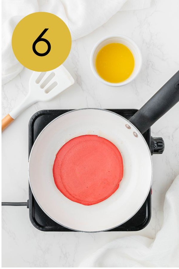 The pancake flipped, showing its cooked red surface.