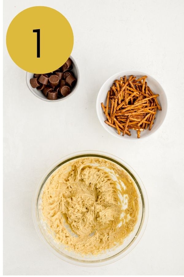 Butter and sugars creamed together in a glass bowl, with Rolos and pretzel sticks alongside.