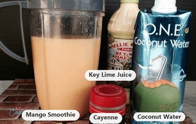 Labeled mango detox smoothie ingredients: the blended mango smoothie, key lime juice, cayenne and coconut water.