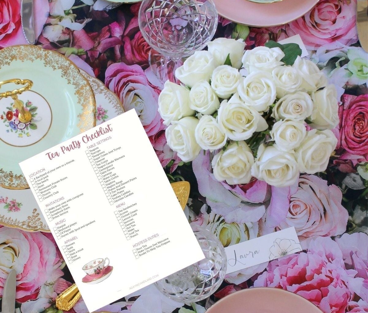 A tea party table with pink and white roses, floral plates and the printable tea party checklist.