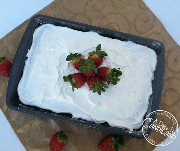 Sparkling Cider Strawberry Poke Cake in pan with strawberries on top