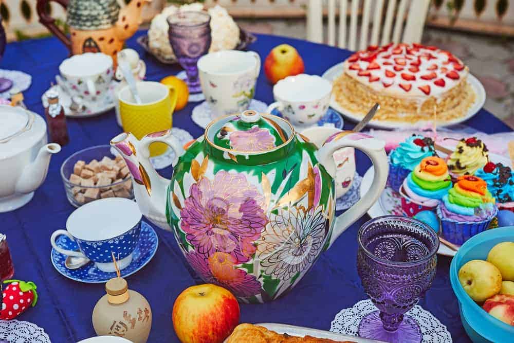 A table full of colorful dishes and set up for tea