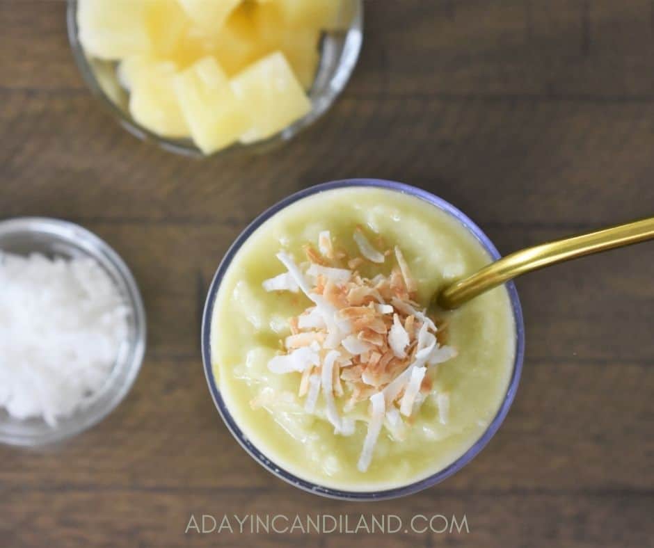 Top angle of Pineapple smoothie with gold metal straw