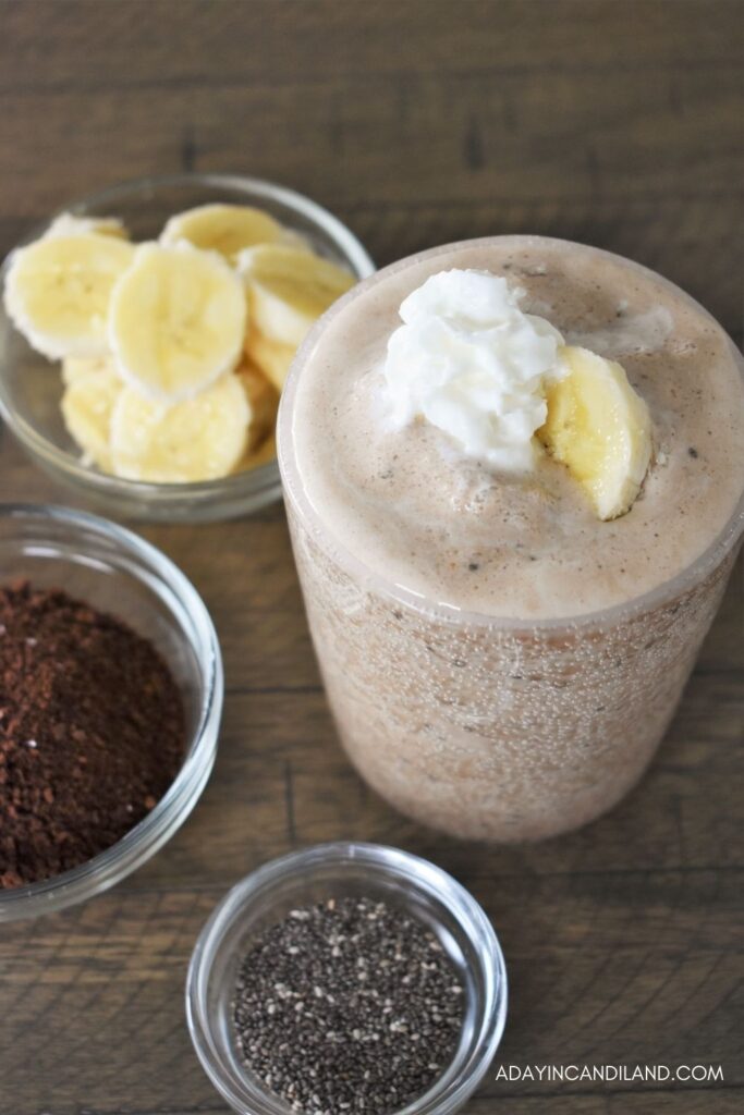 Glass of Cold Brew Smoothie with cup of bananas, chia seeds and coffee grounds
