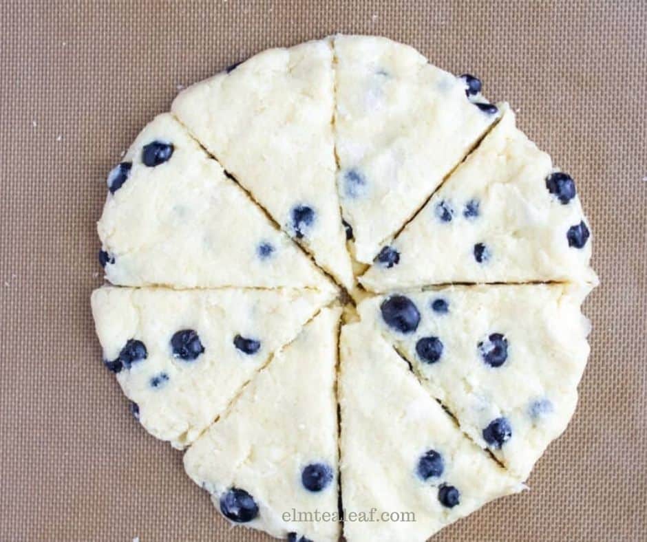 The scone dough patted into a disc and cut into 8 wedges.