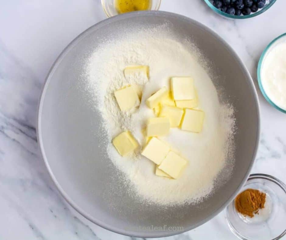 Cubes of cold butter added to the sifted dry ingredients.