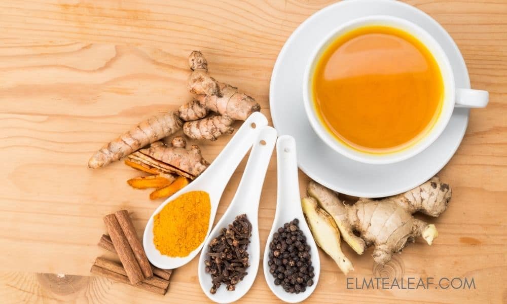 Cup of Turmeric Tea with ginger, clove and peppercorns on the table 
