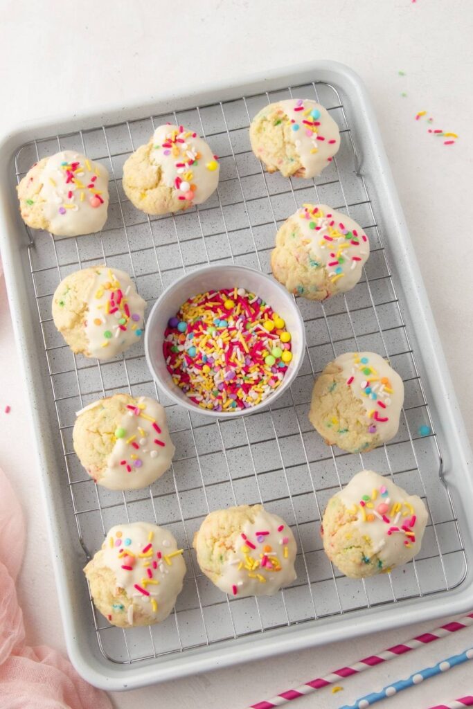 Cookies on baking tray with a bowl of sprinkles 