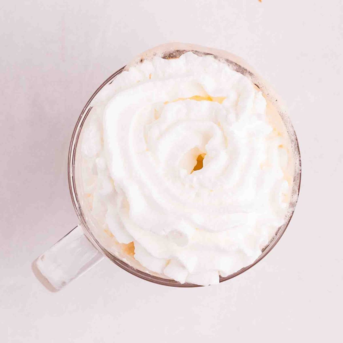 Whipped cream added on top of the latte.