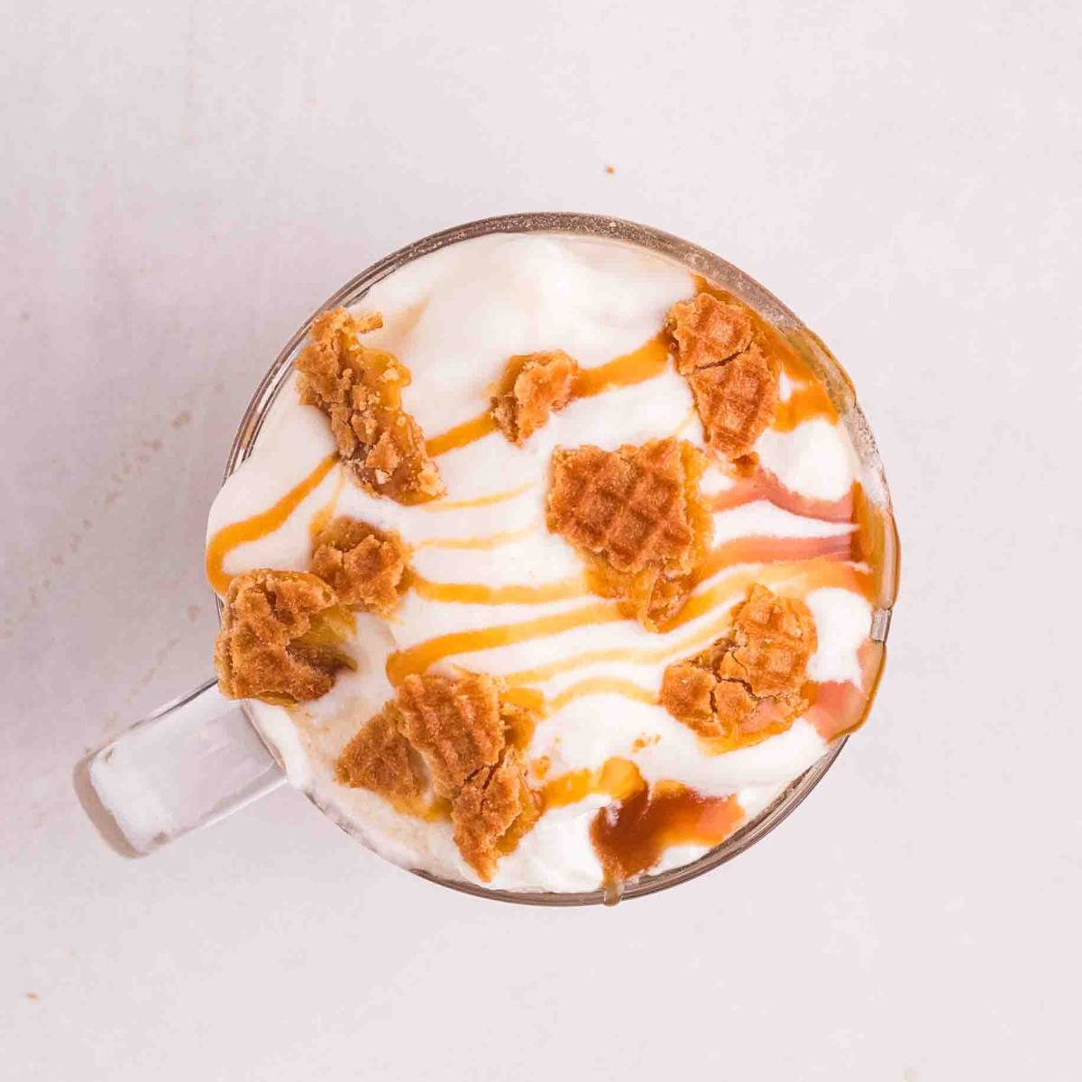 Chopped waffle cookies and a caramel drizzle finishing the latte.
