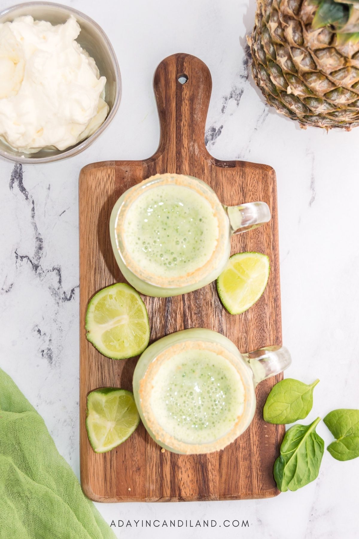 Two glasses filled with Key Lime Smoothies with Limes.