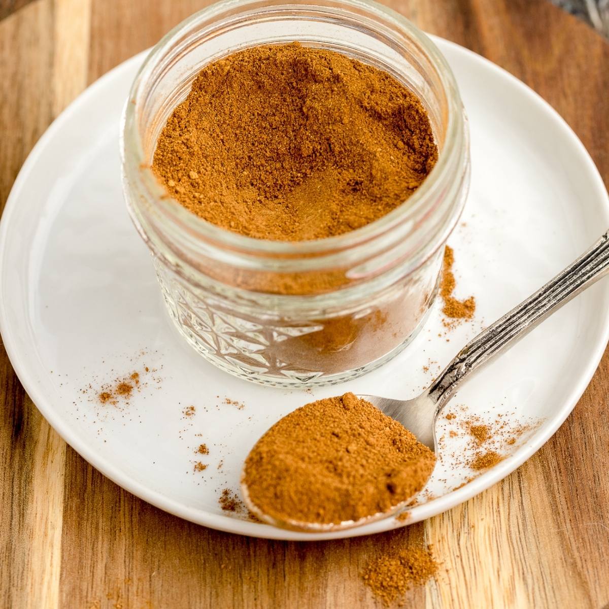 Jar of Pumpkin Pie Spice on a white plate. 