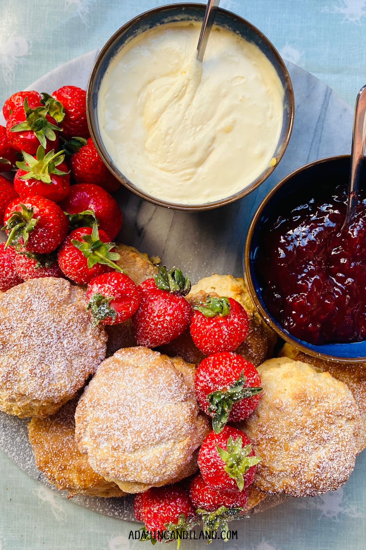 Strawberries, scones, and jam on a table. 