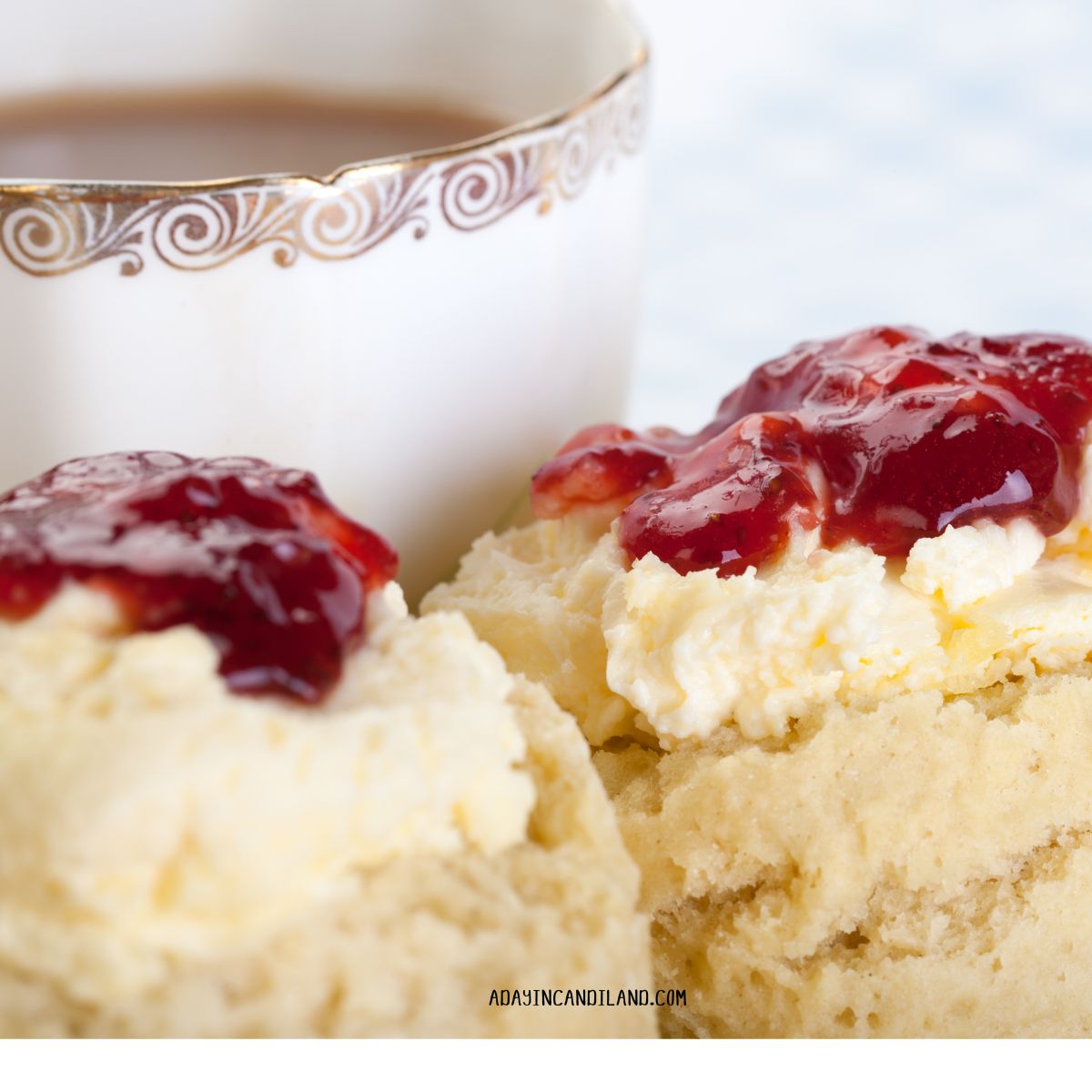 Two scones with jam and a cup of tea.