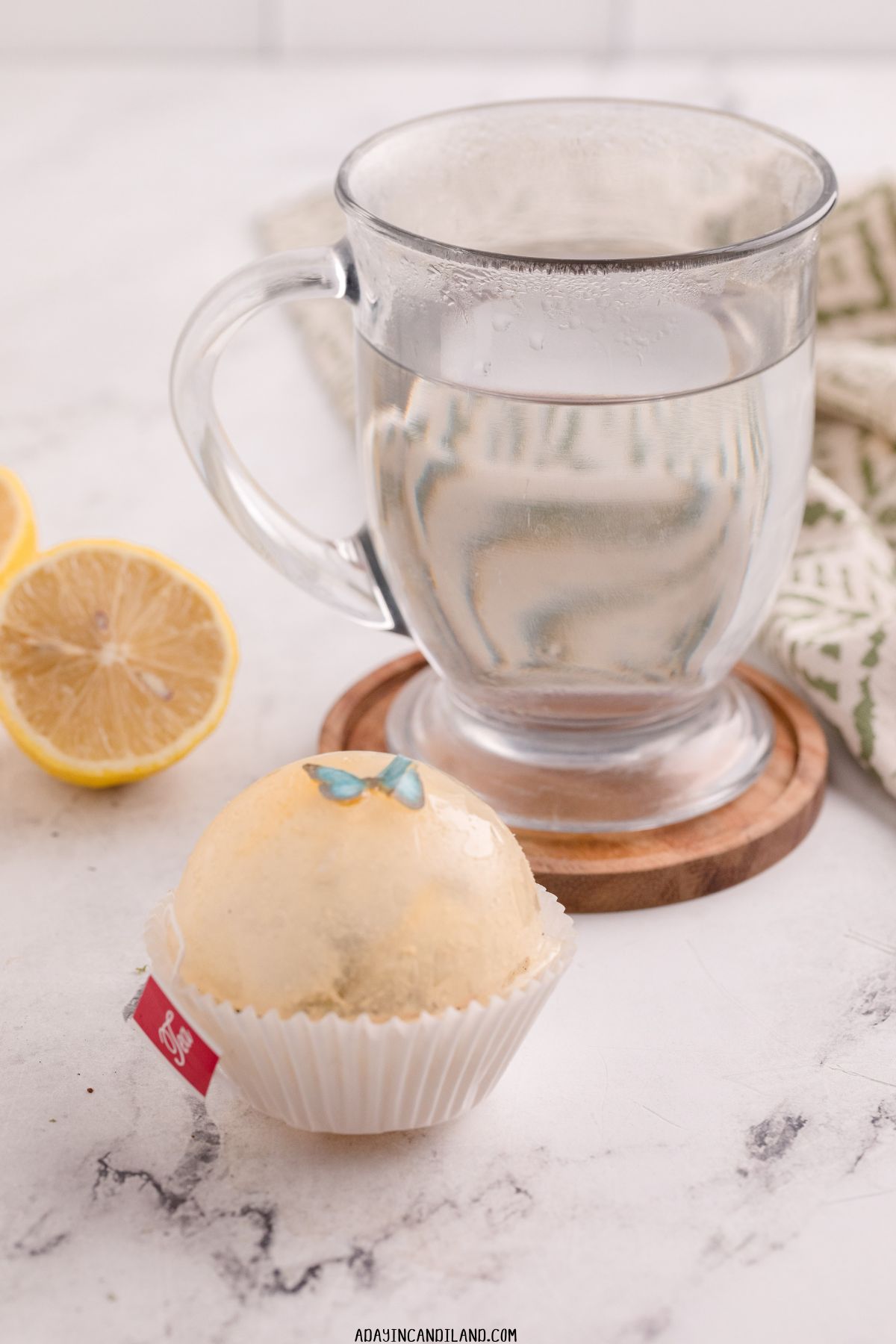 Glass of Hot Water with a Tea Bomb and Lemon wedge. 