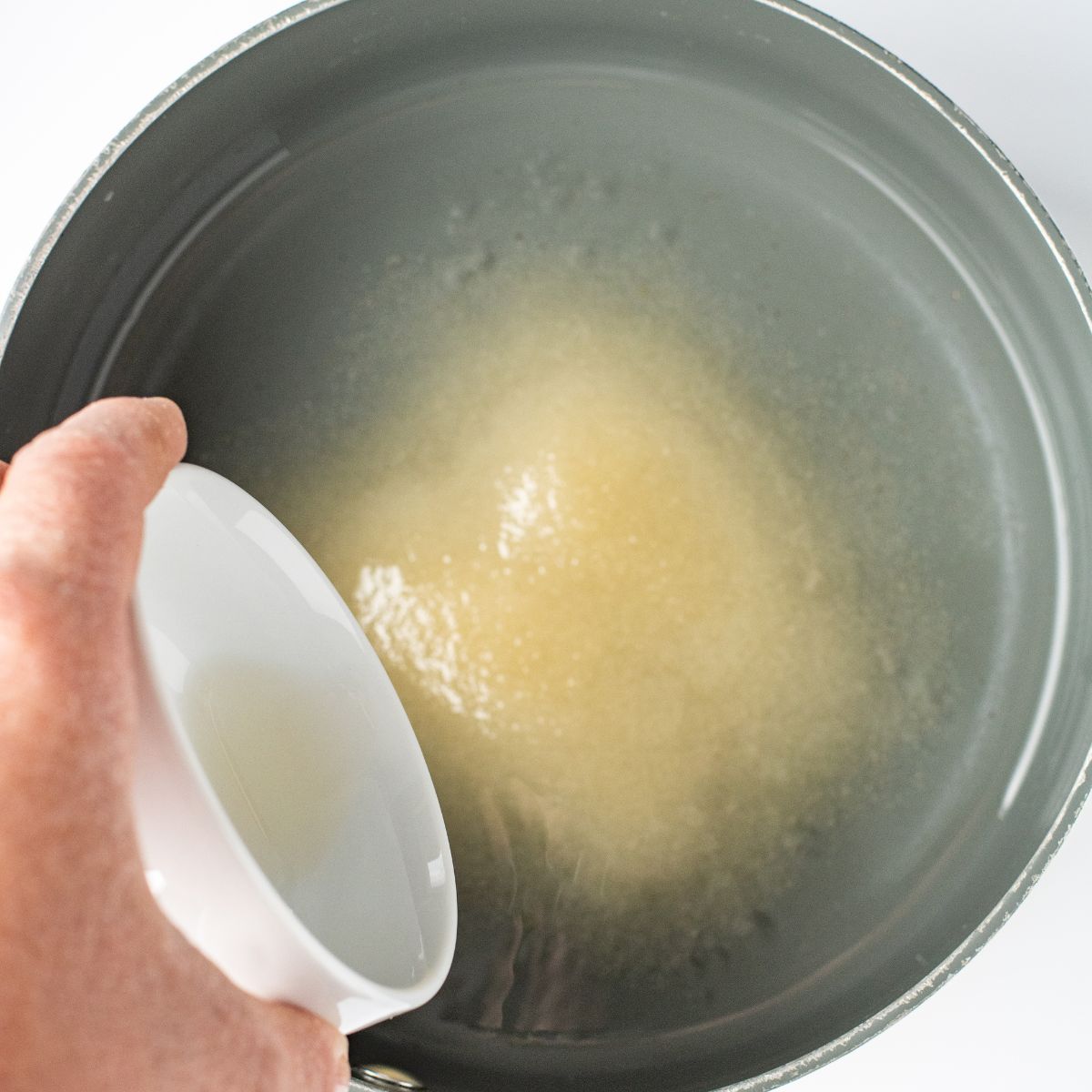 Cane sugar, vanilla and water being added to a saucepan for the simple syrup.