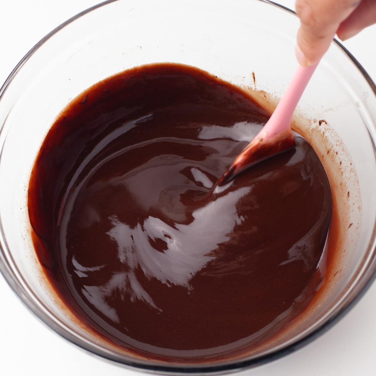 Butter and dark chocolate melted together until glossy in a glass bowl.