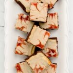 White plate of strawberry cheesecake brownies.