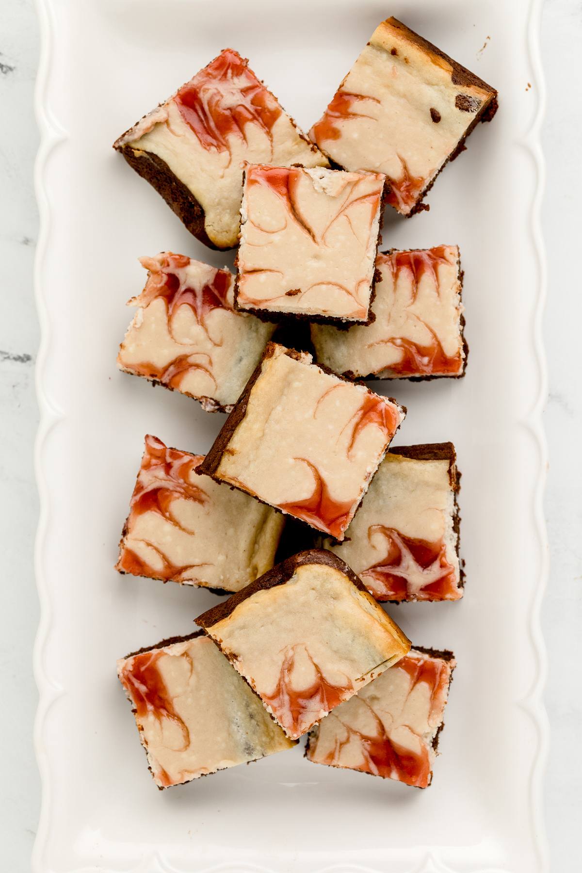 White plate of strawberry cheesecake brownies.