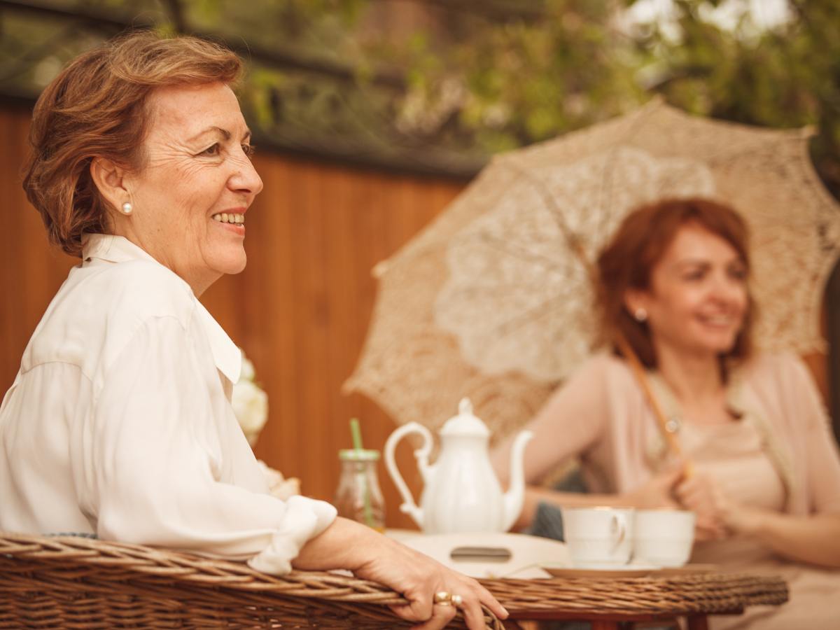 Two moms sitting at a tea table.