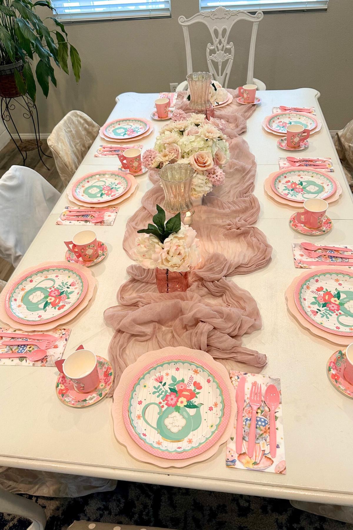 Table set up with candles, flowers and plates. 