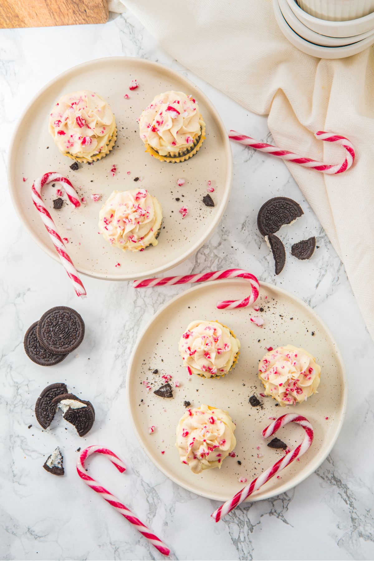 Mini Peppermint Cheesecakes on a plate with some Candy Canes.