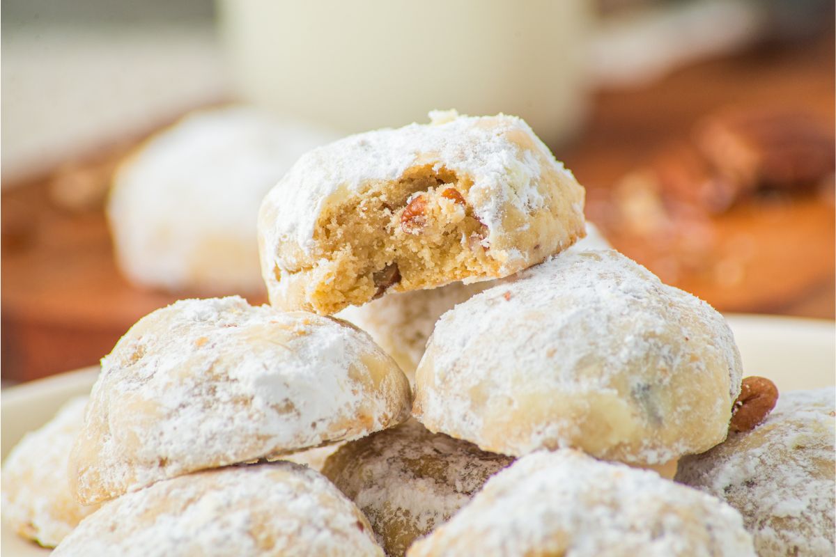 Upclose image of plate of stacked snowball cookies. 