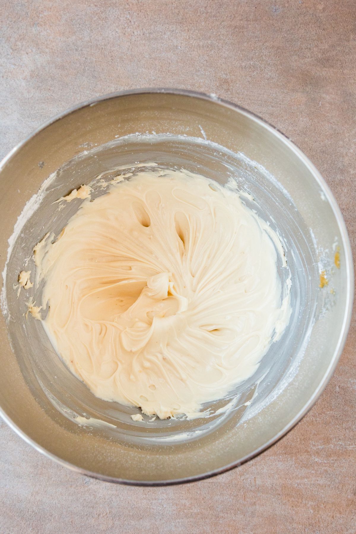 Whipped caramel cream cheese frosting in the mixer bowl.