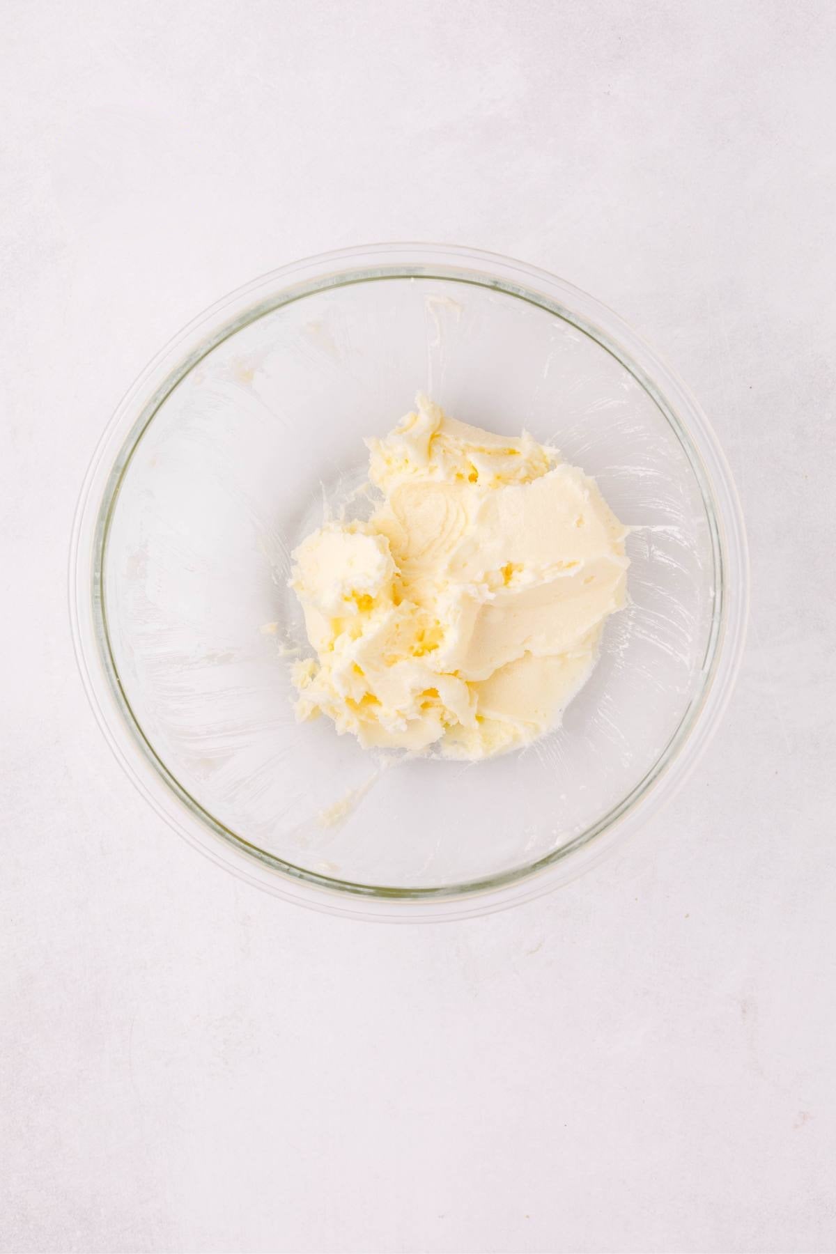 Butter and sugar creamed together in a glass mixing bowl.