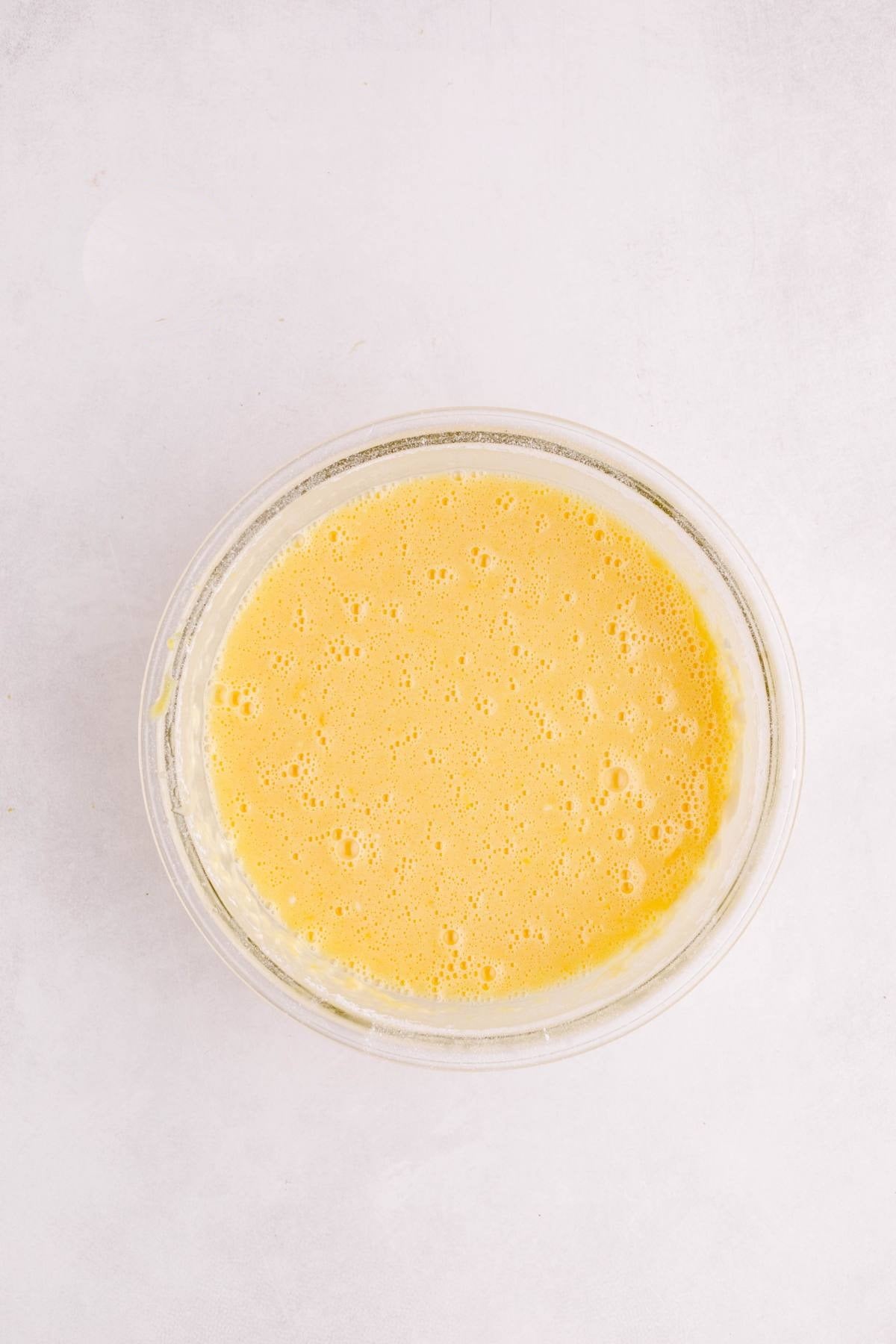 Lemon bar filling whisked together in a glass bowl.