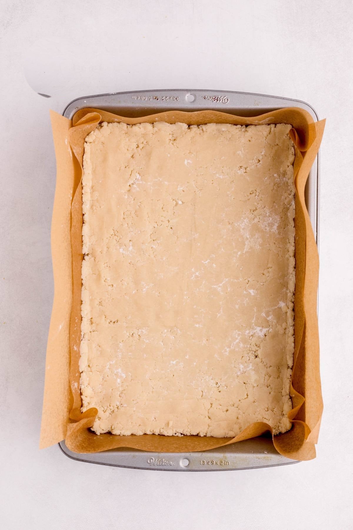 Shortbread crust pressed into a foil-lined 9 by 13 pan.