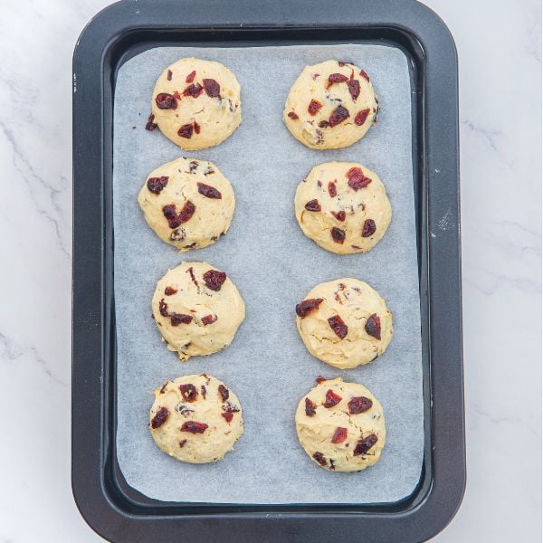Add scooped cookie dough to the parchment paper lined cookie sheet and bake.
