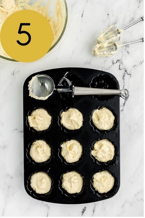 Lemon batter scooped into a mini bundt pan, about two thirds full.
